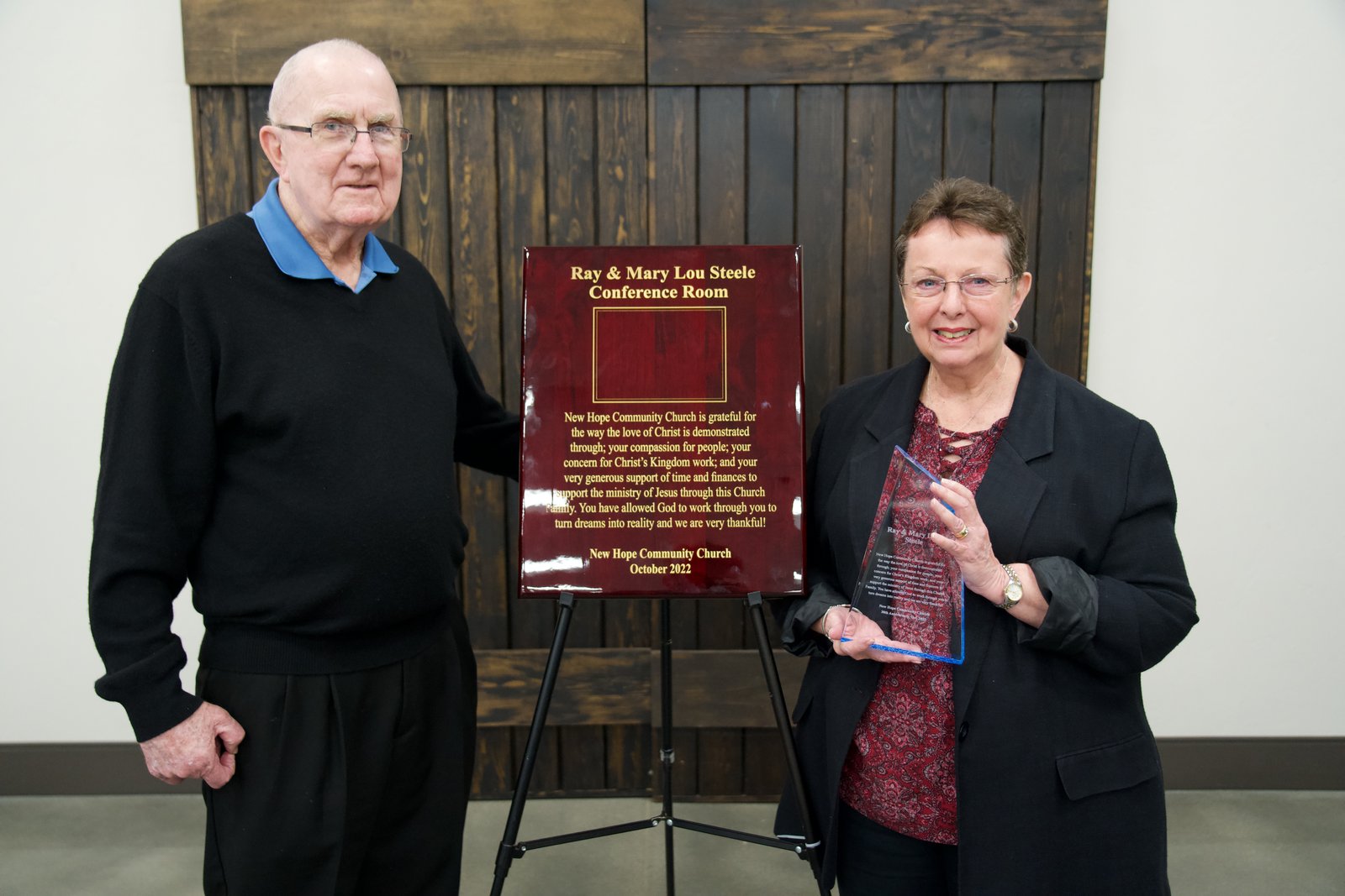Ray and Mary Lou Steele standing beside the dedication plaque for the Ray and Mary Lou Steele Conference Room at New Hope