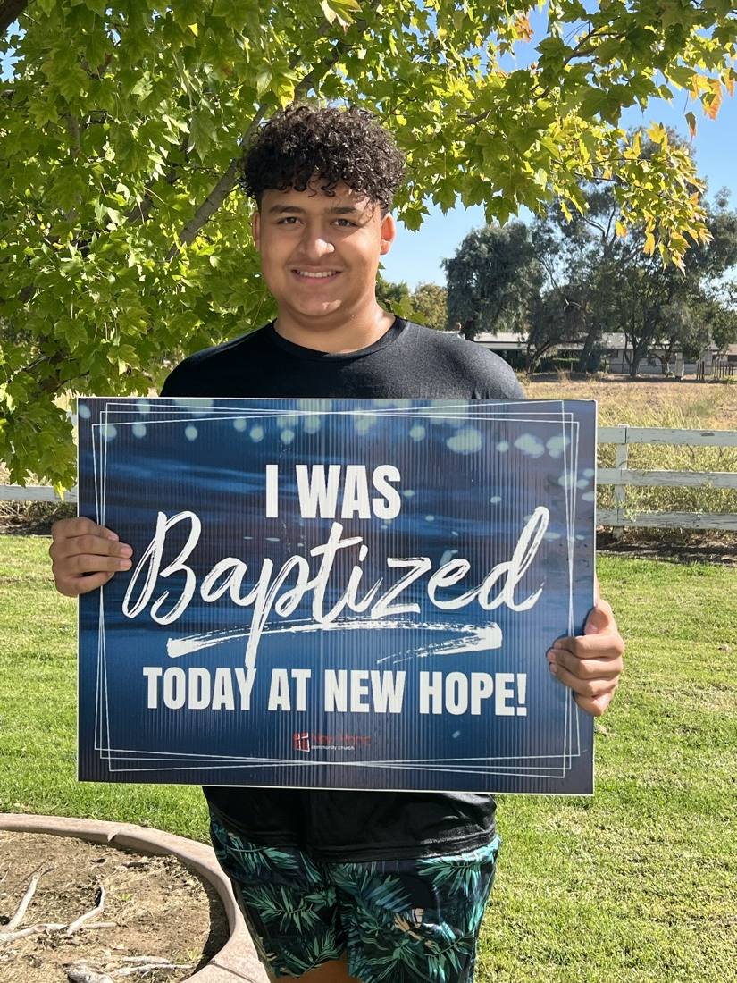 A New Hope member with an I was baptized today sign after baptism