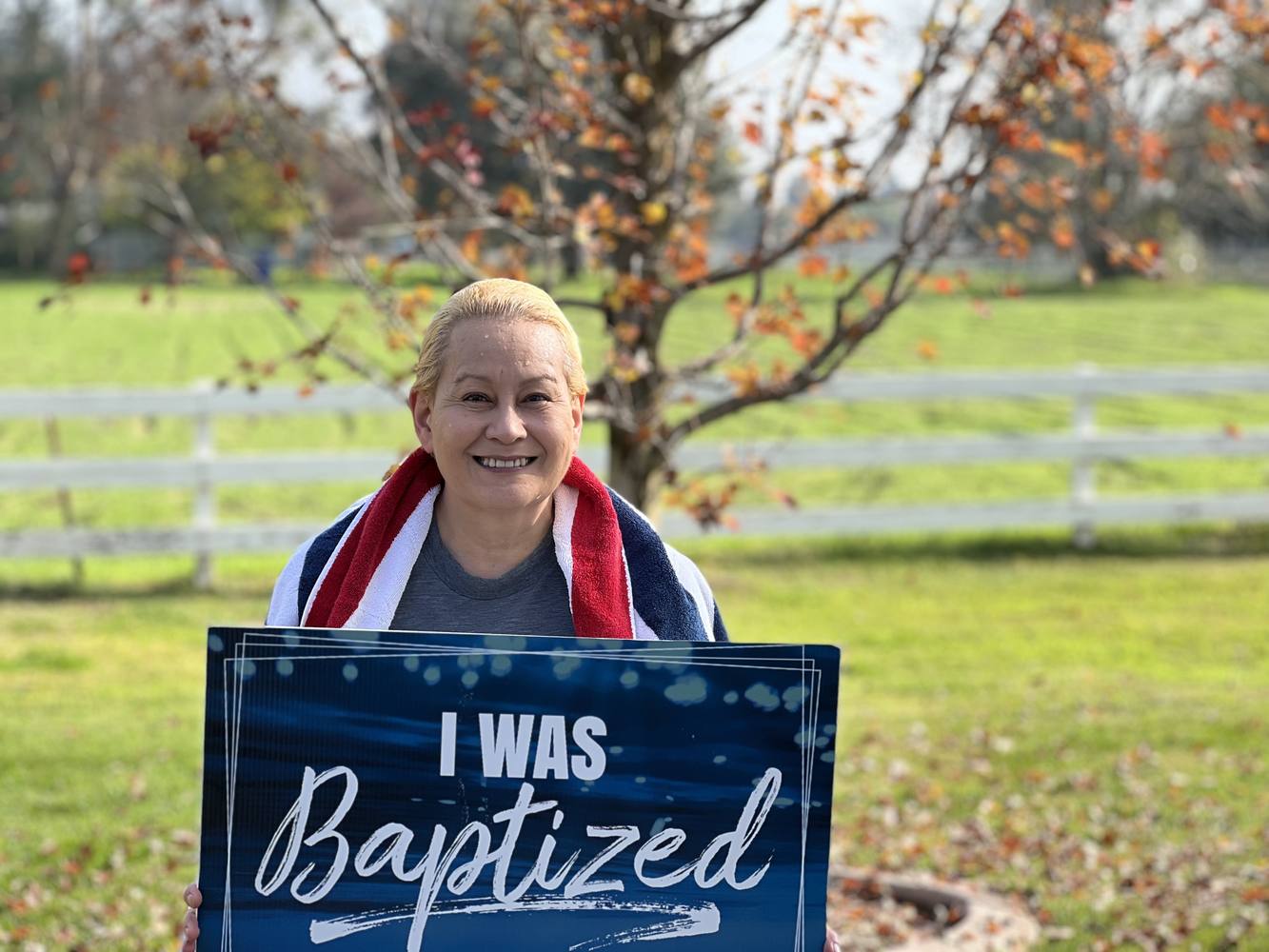 A New Hope member holding an I was baptized today at New Hope sign on the church lawn