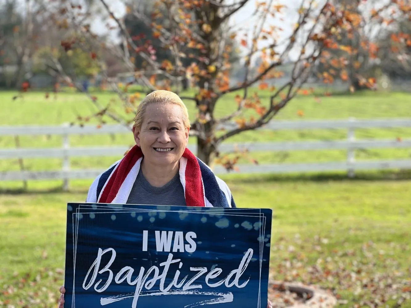 A New Hope member holding an I was baptized today at New Hope sign on the church lawn