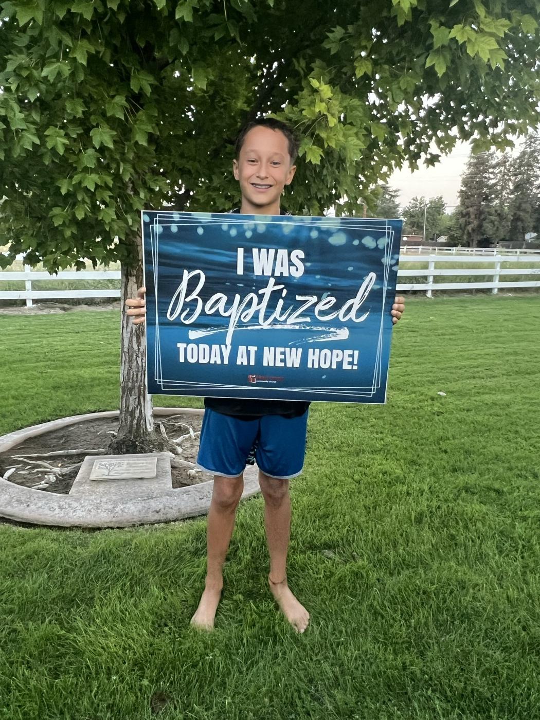 A young believer beaming on the church lawn after being baptized at New Hope