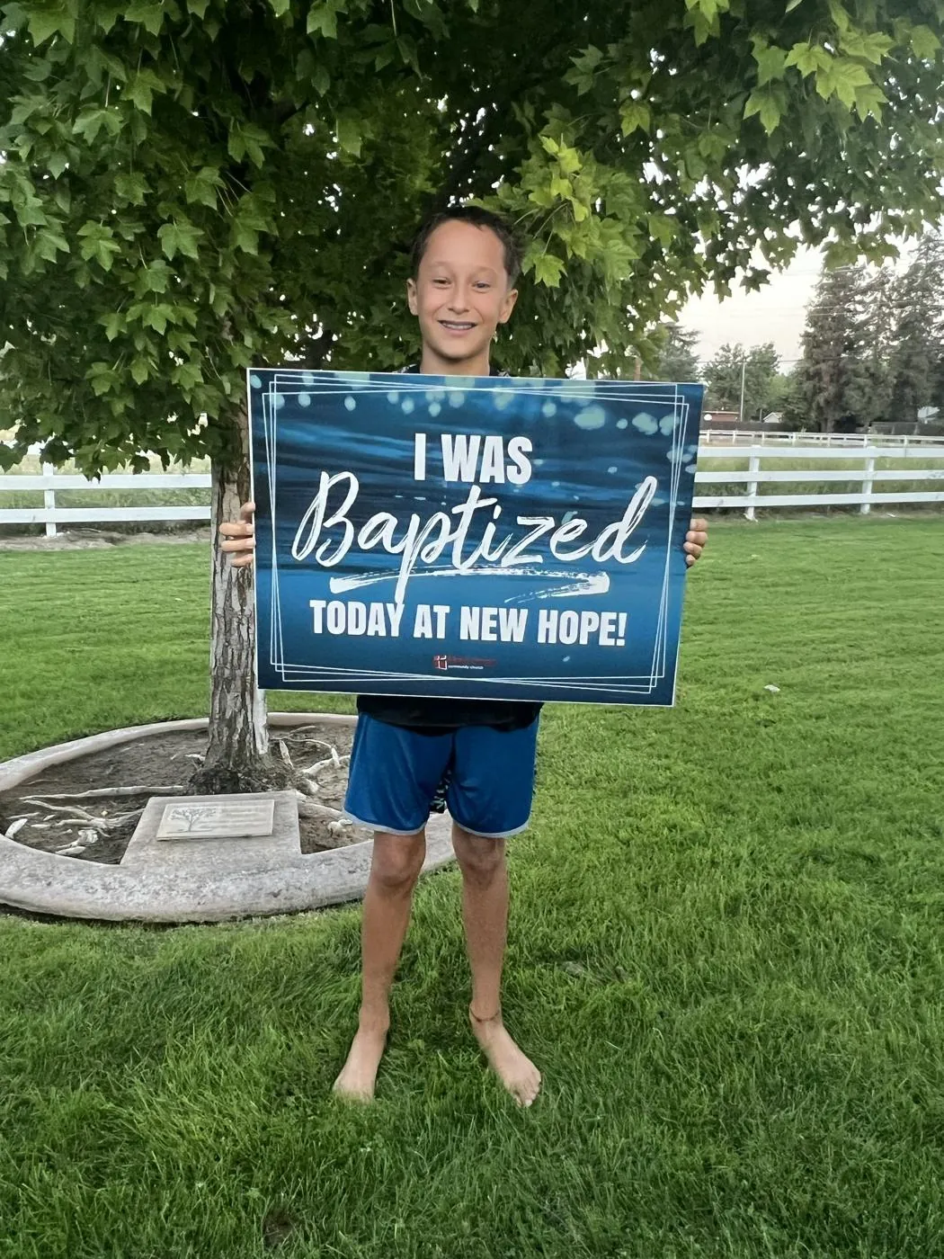 A young believer beaming on the church lawn after being baptized at New Hope