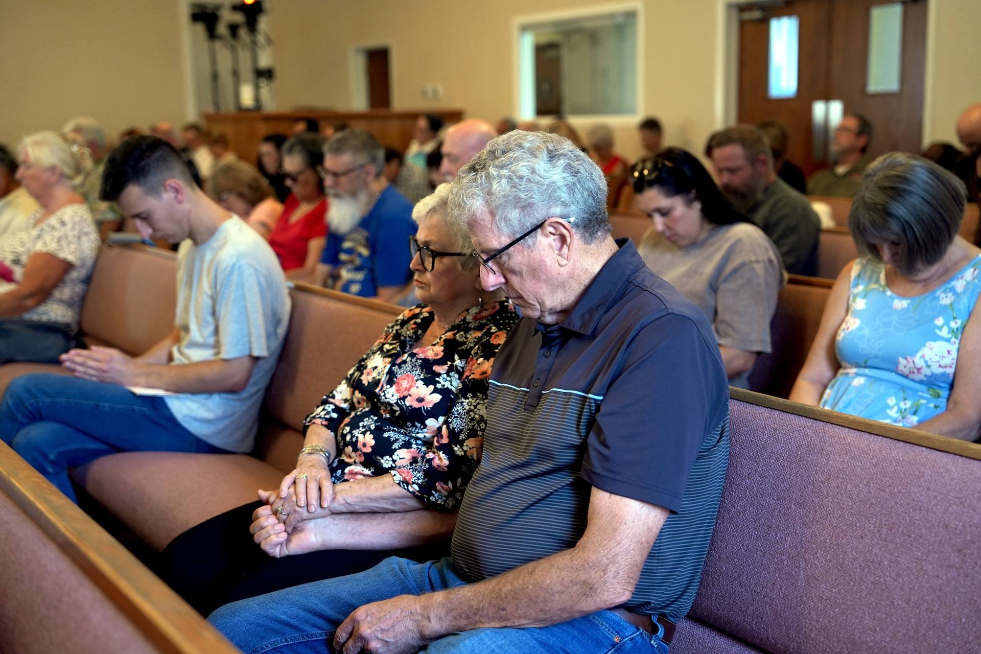 People of all ages gathered and bowed together in prayer at New Hope