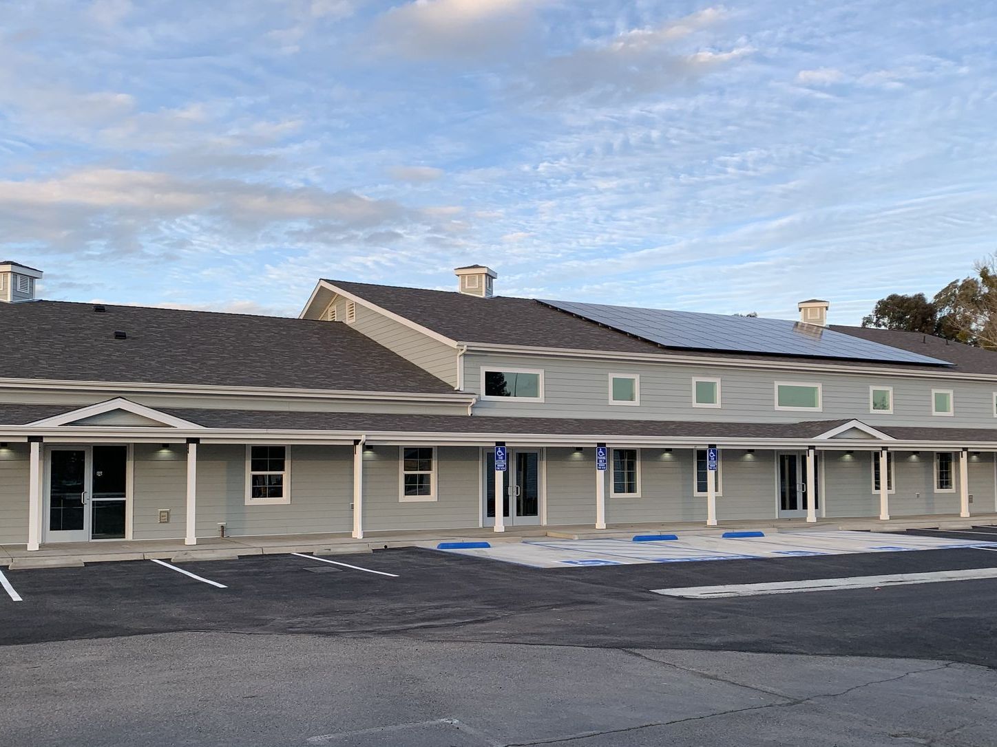 The New Hope campus buildings in Clovis at dusk, covered walkways and accessible parking bays in front