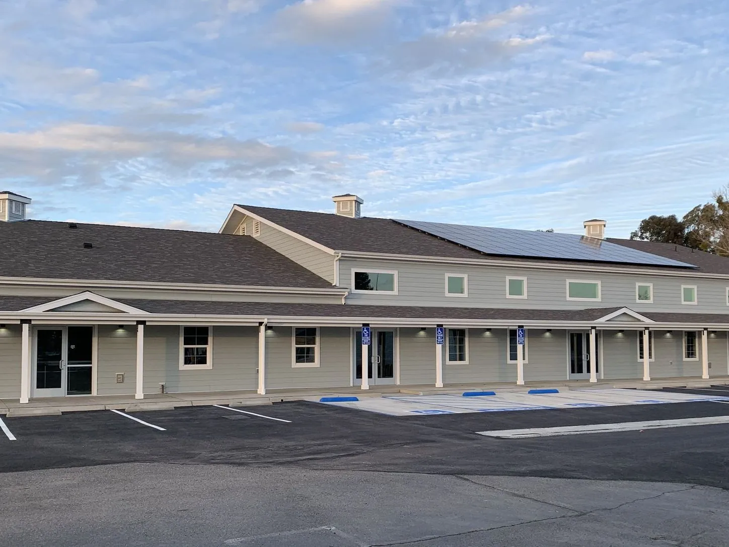 The New Hope campus buildings in Clovis at dusk, covered walkways and accessible parking bays in front
