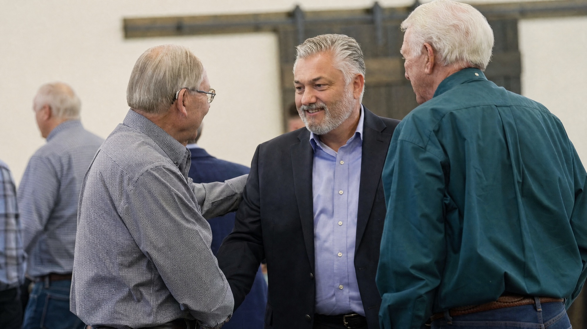 Pastor Mark Addis in conversation with two men in The Barn at New Hope