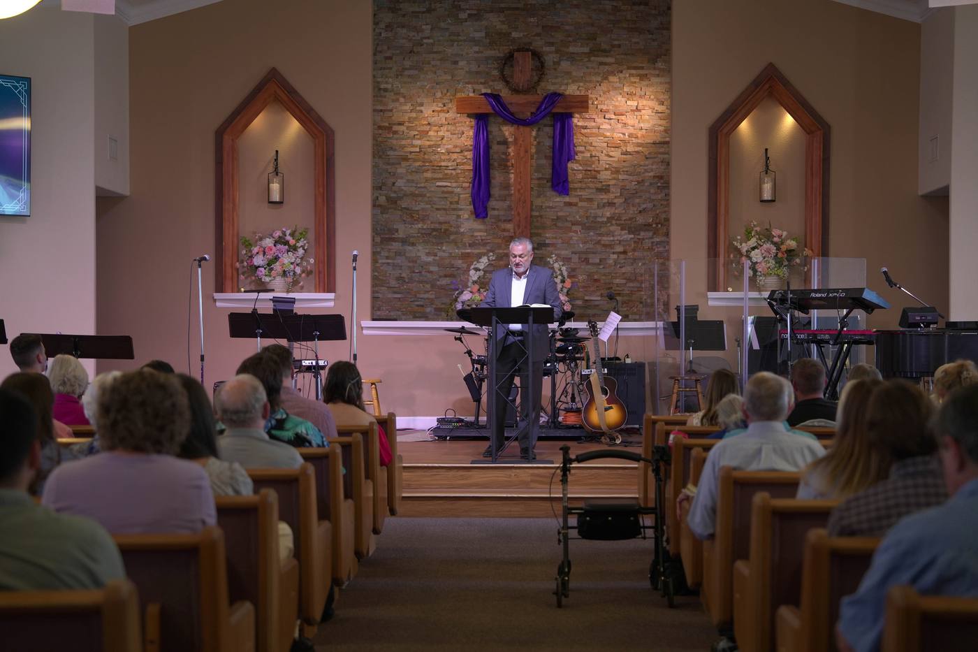 New Hope's sanctuary decorated for Easter, with a purple-draped cross and spring flowers