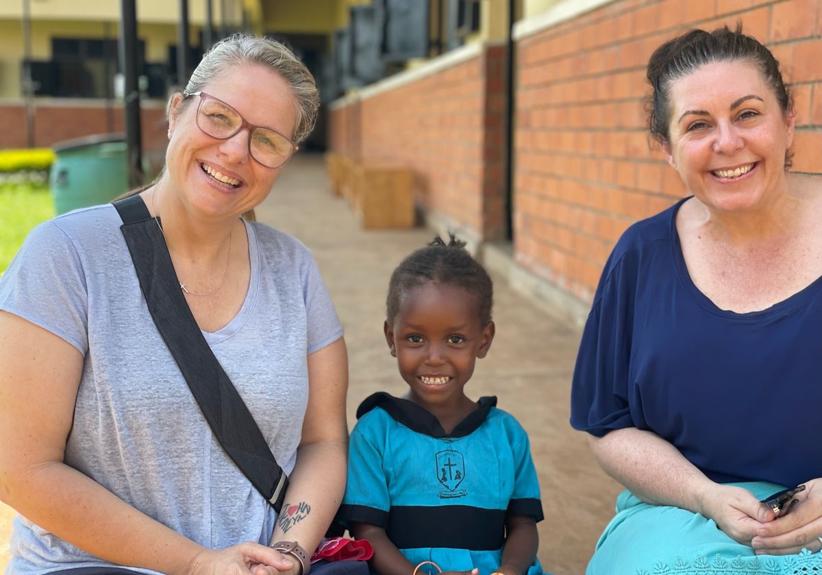 New Hope mission team members with a child in Uganda