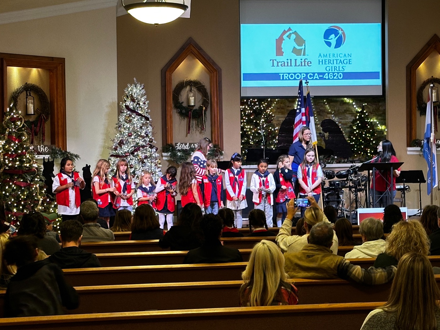 A joint ceremony of the AHG and Trail Life Troop CA-4620 troops on the New Hope sanctuary stage, both troop banners visible