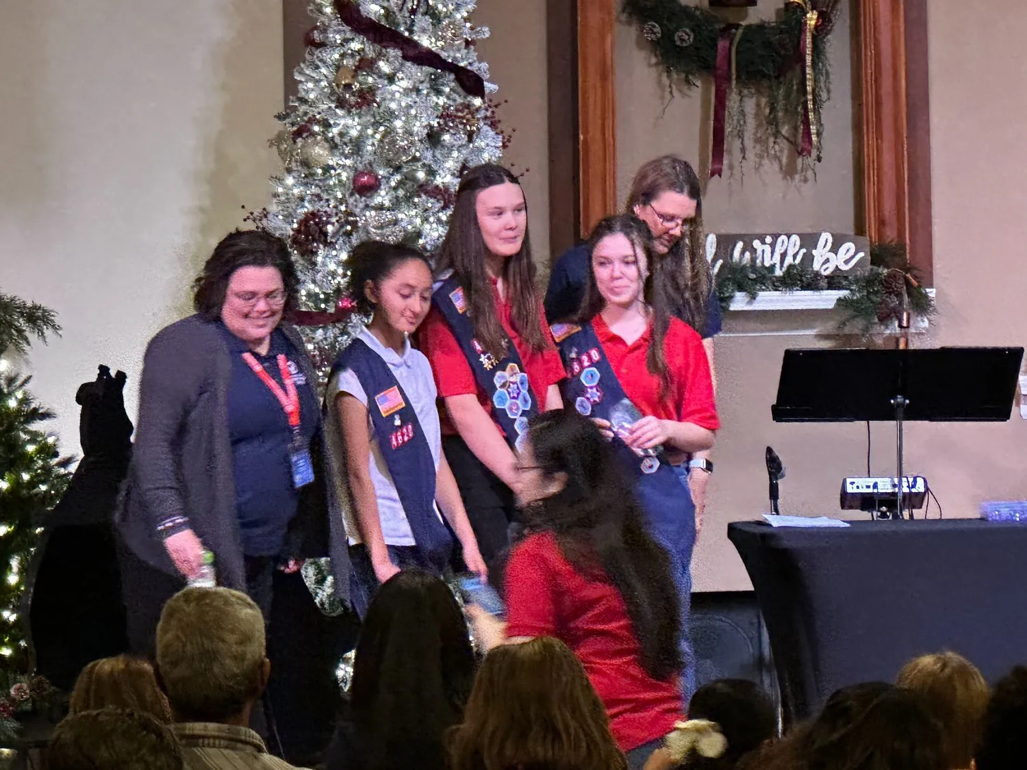 Troop CA-4620 girls in their American Heritage Girls sashes standing with their leaders at a New Hope ceremony
