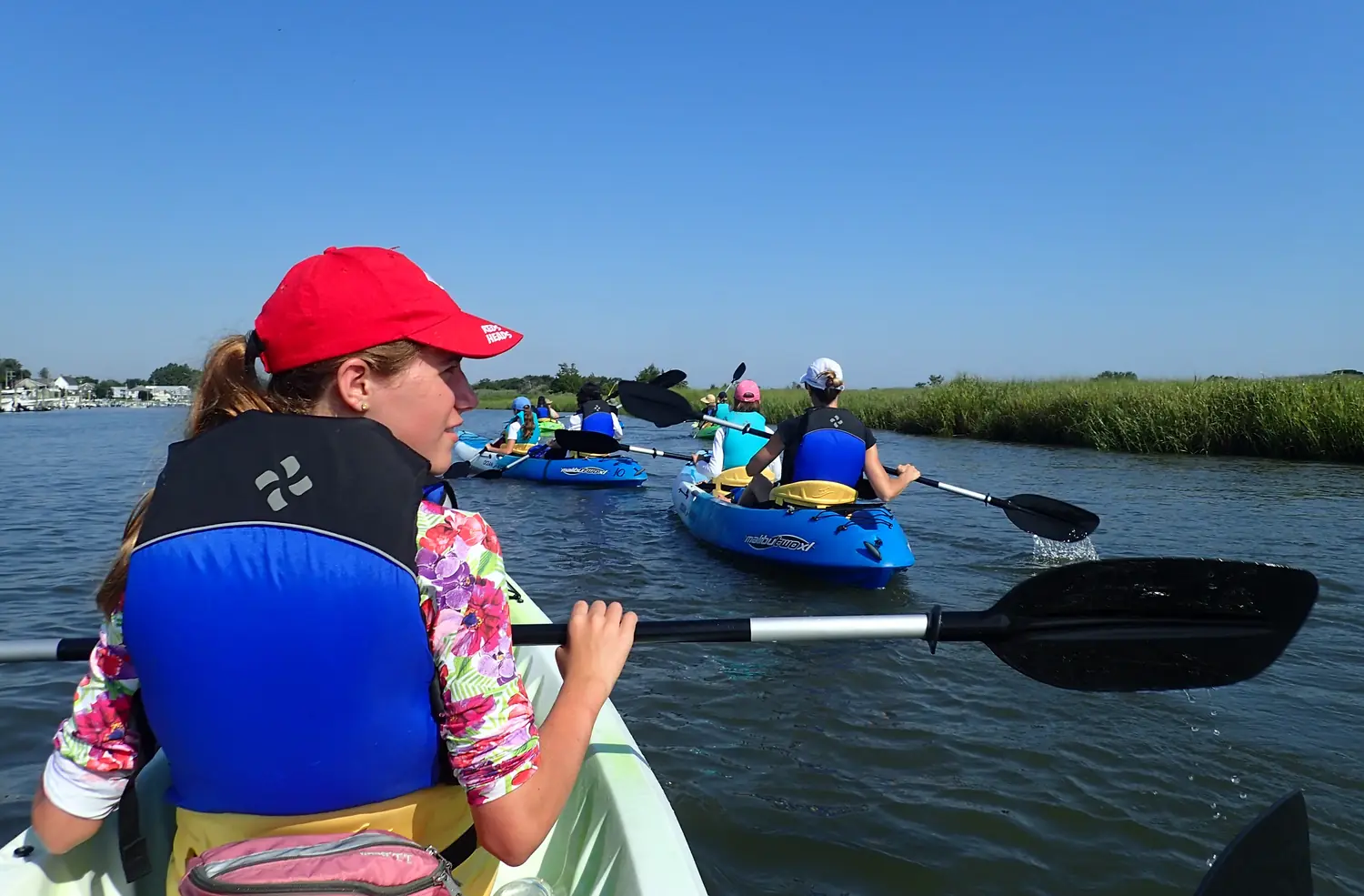 American Heritage Girls paddling kayaks on open water