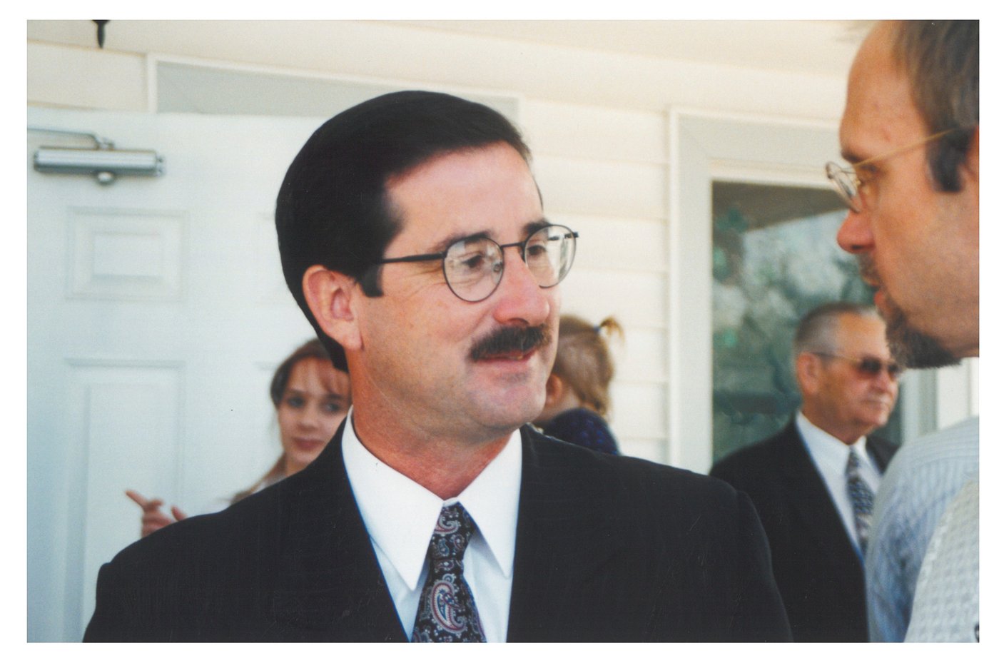 Pastor Tim McLain Rolen, dark suit and patterned tie, in conversation