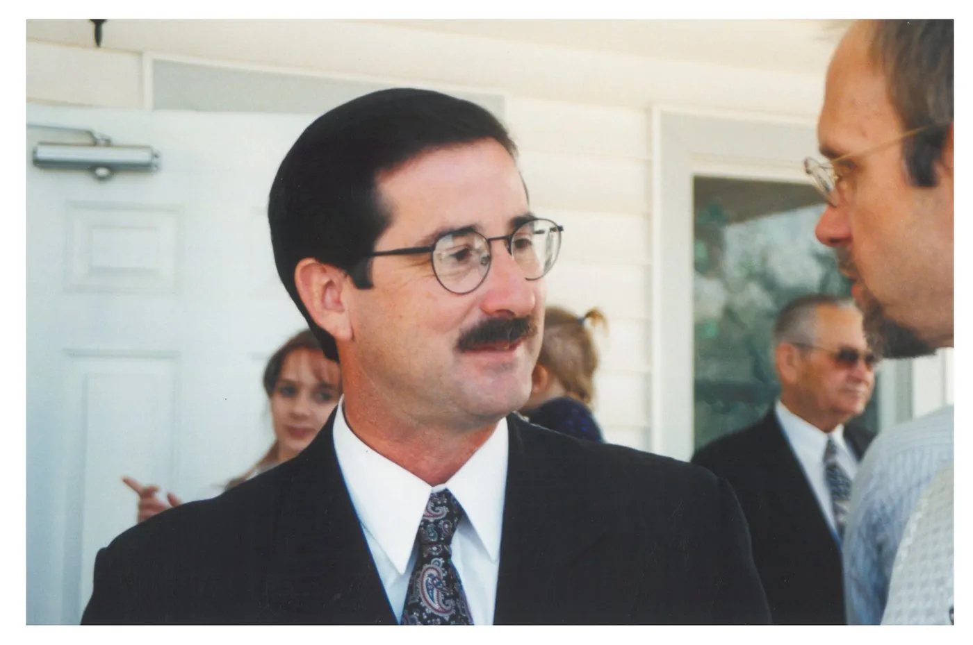 Pastor Tim McLain Rolen, dark suit and patterned tie, in conversation