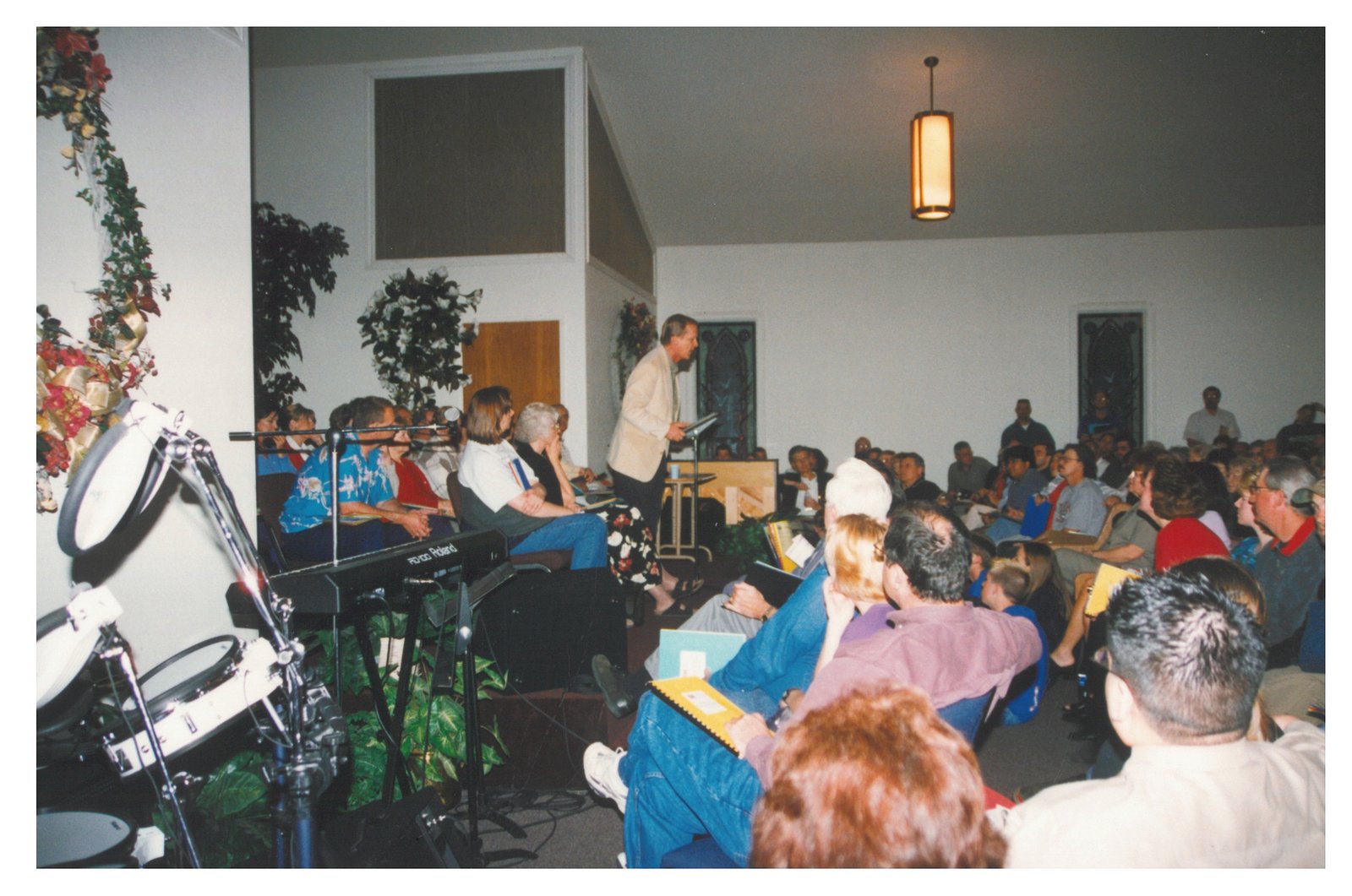 The front of the New Hope sanctuary during a packed service, with worship team and a Roland keyboard