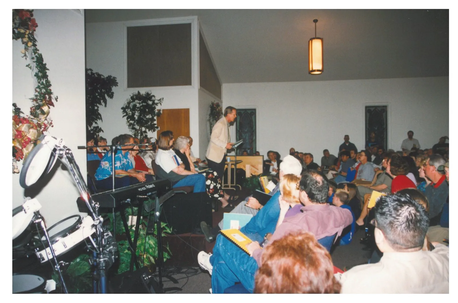 The front of the New Hope sanctuary during a packed service, with worship team and a Roland keyboard