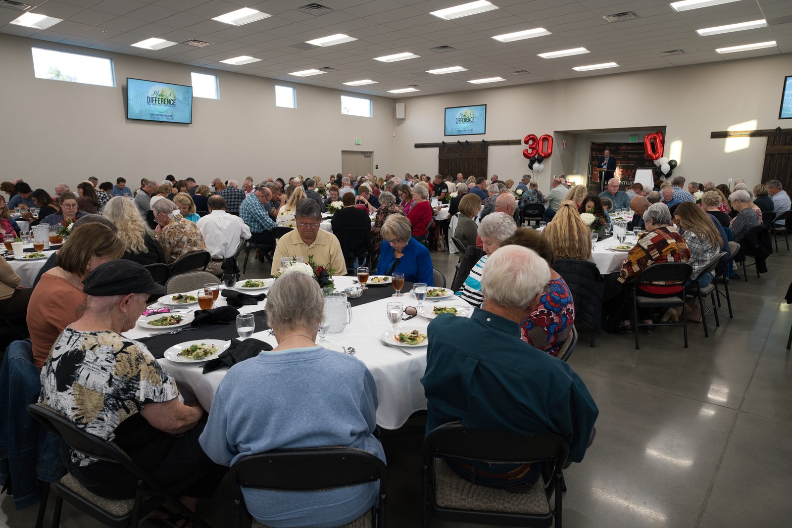 The 30-year anniversary dinner in The Barn at New Hope, October 2022, with over three hundred past and current members at round tables