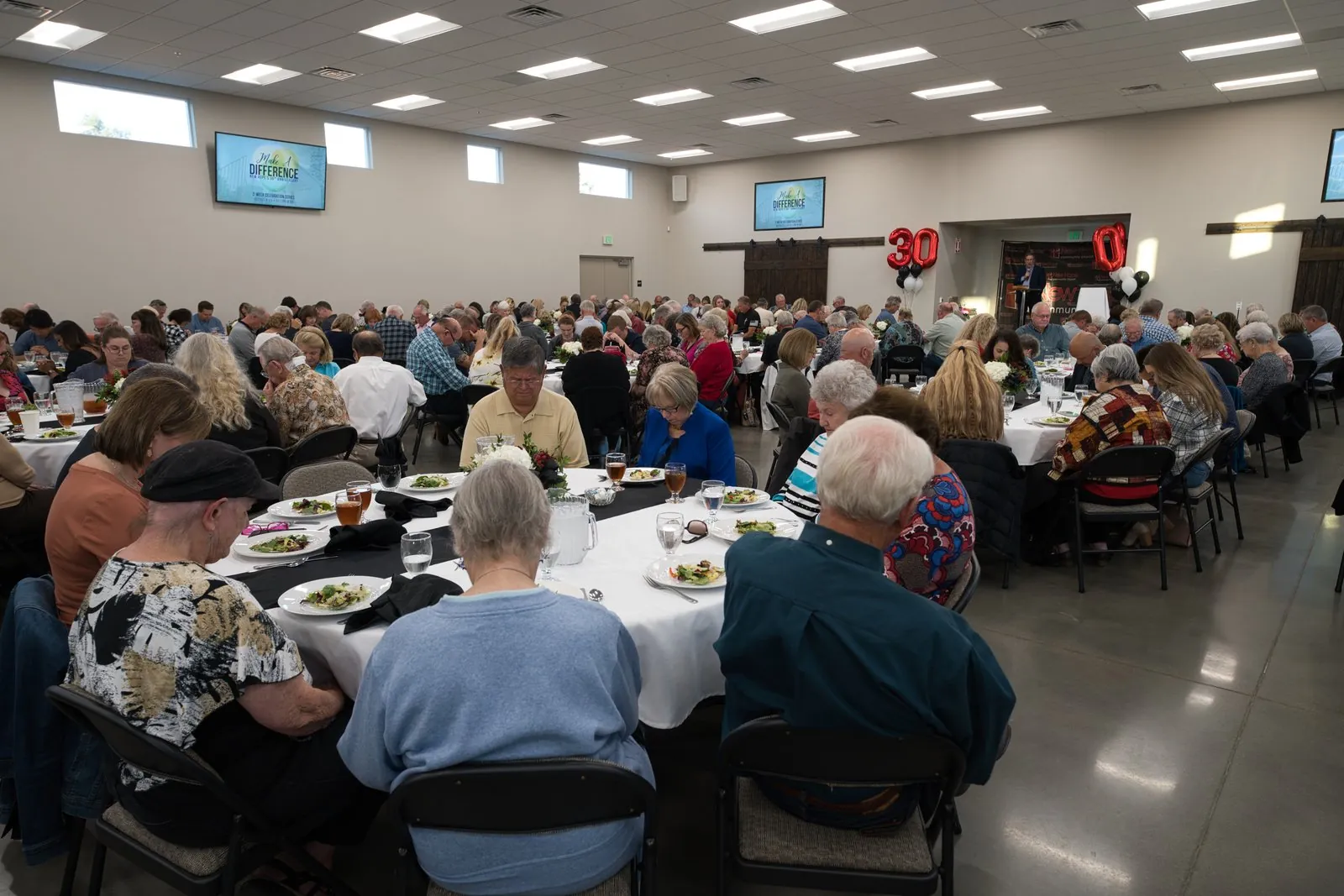 The 30-year anniversary dinner in The Barn at New Hope, October 2022, with over three hundred past and current members at round tables