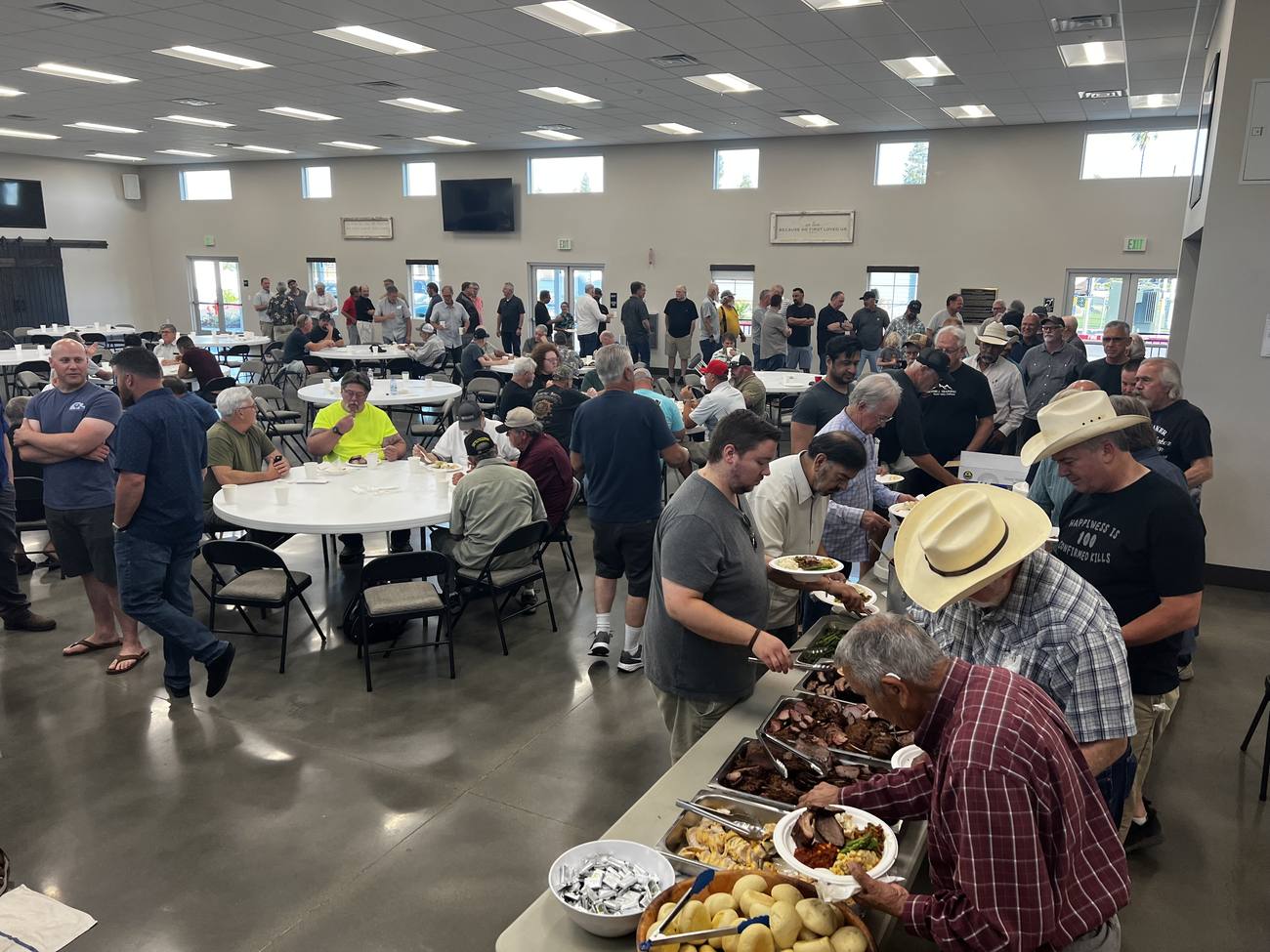 Men of New Hope serving plates down the line at the Men's BBQ
