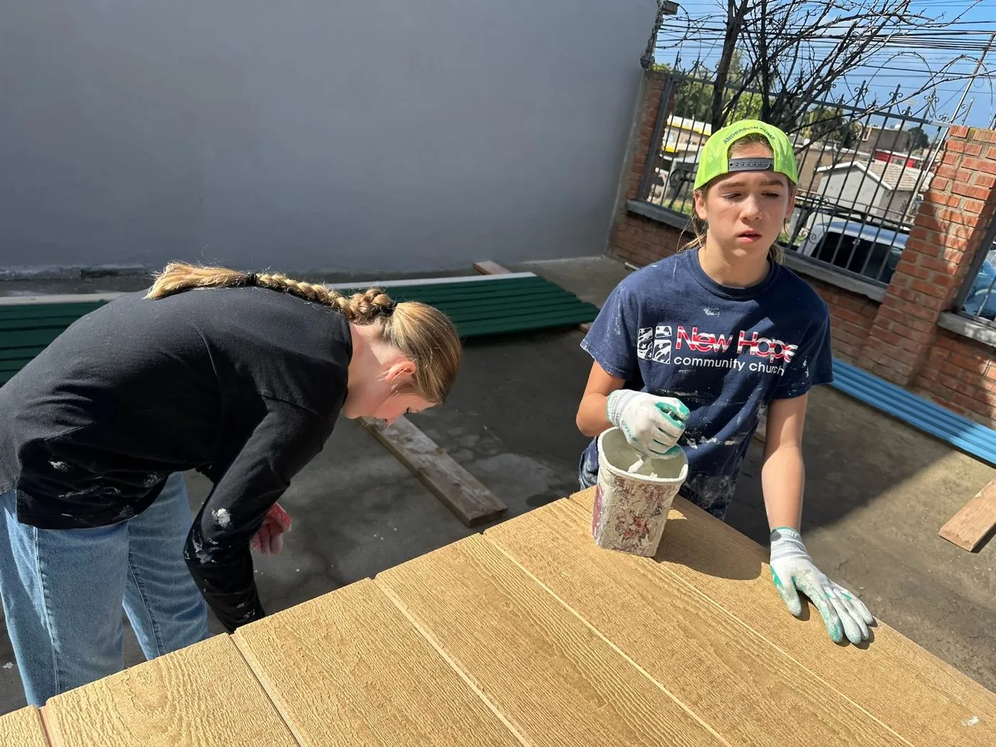 New Hope team members staining wood paneling at the Mexico build site