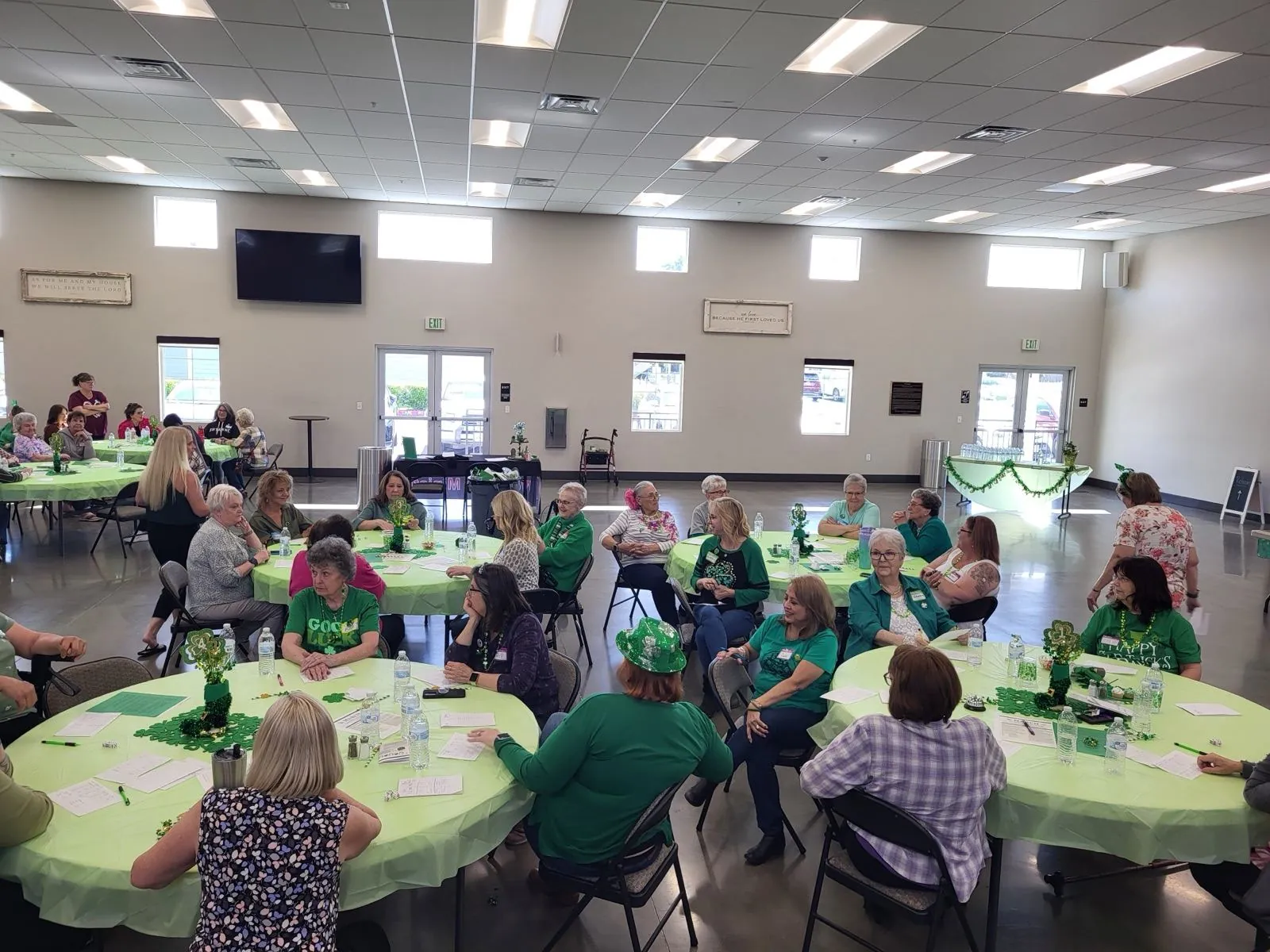 A roomful of New Hope women gathered around tables at a Women's Ministry tea in The Barn