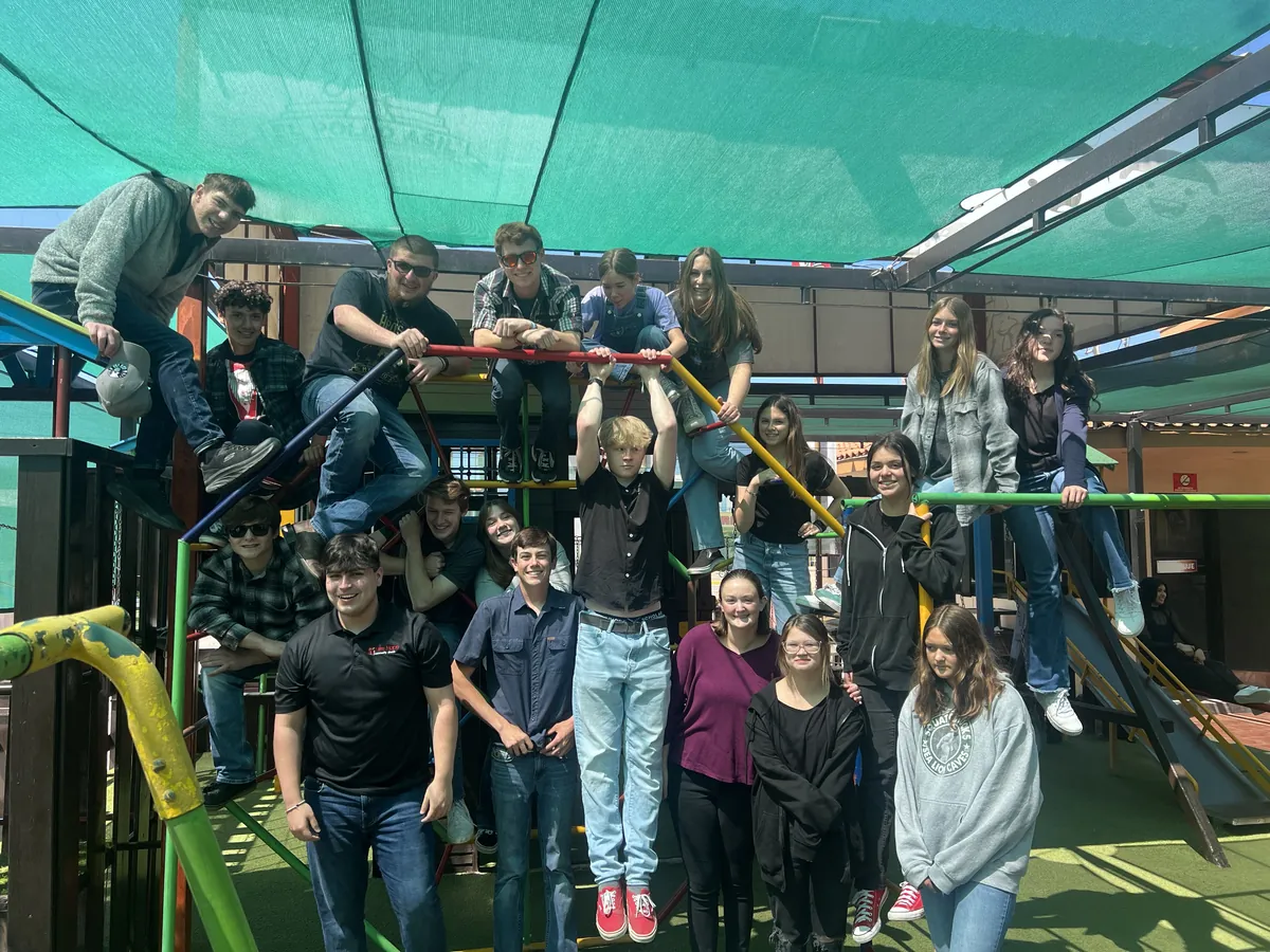 New Hope students and youth leaders posing on a playground climbing frame during the 2023 student mission trip to Mexico