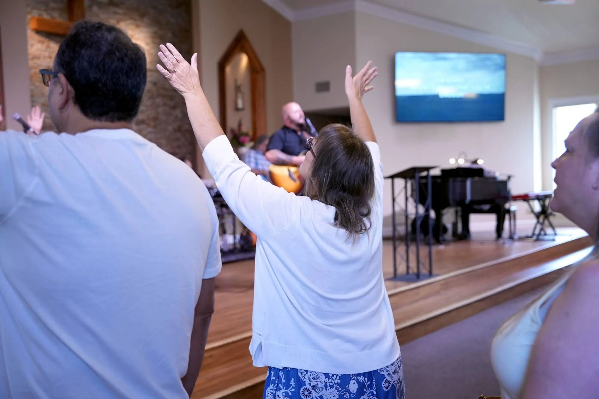 Hands raised in worship as the band leads a New Hope gathering in Clovis