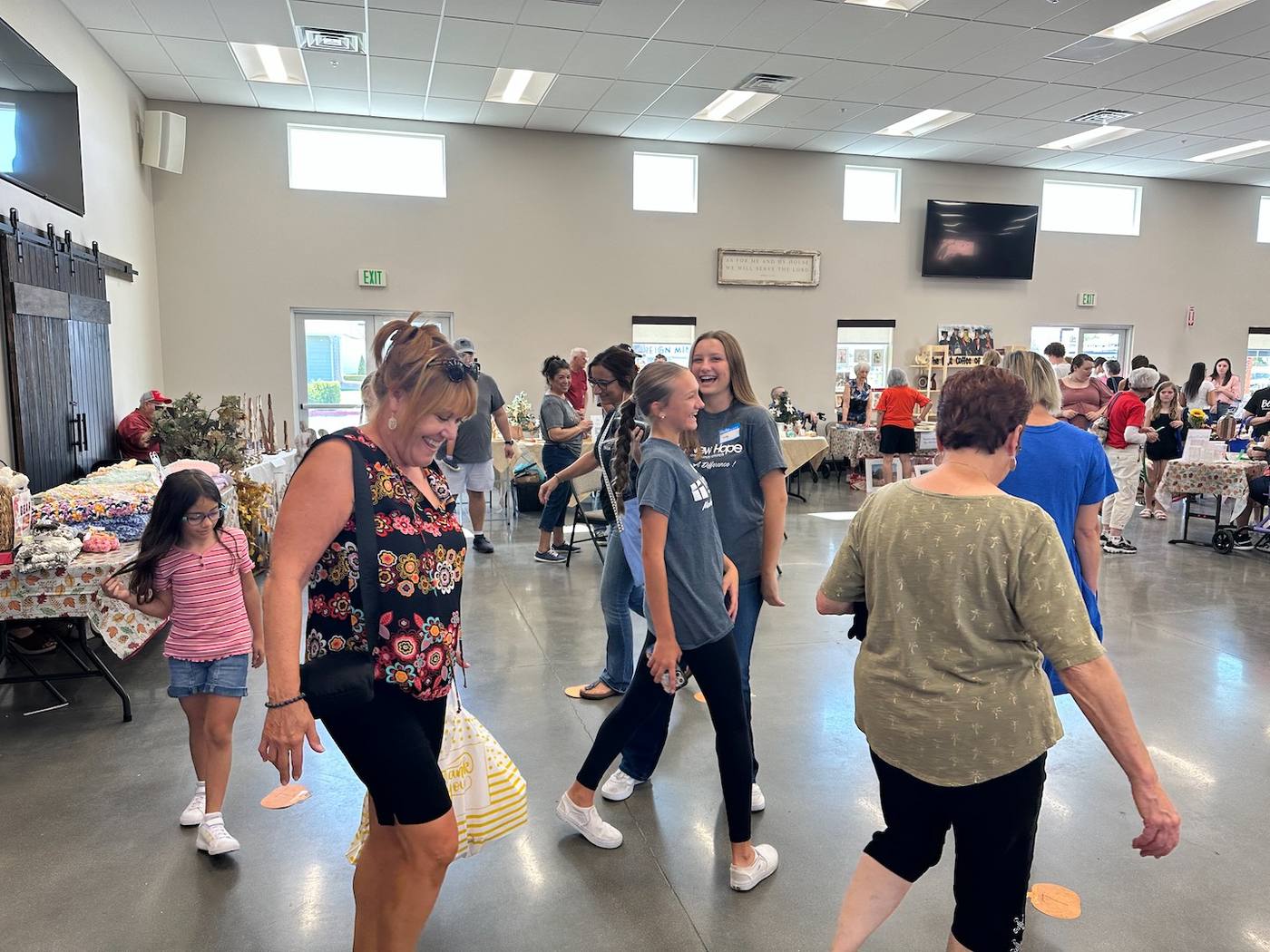 Children, teens, and adults laughing together in the hall at the New Hope fall festival in Clovis