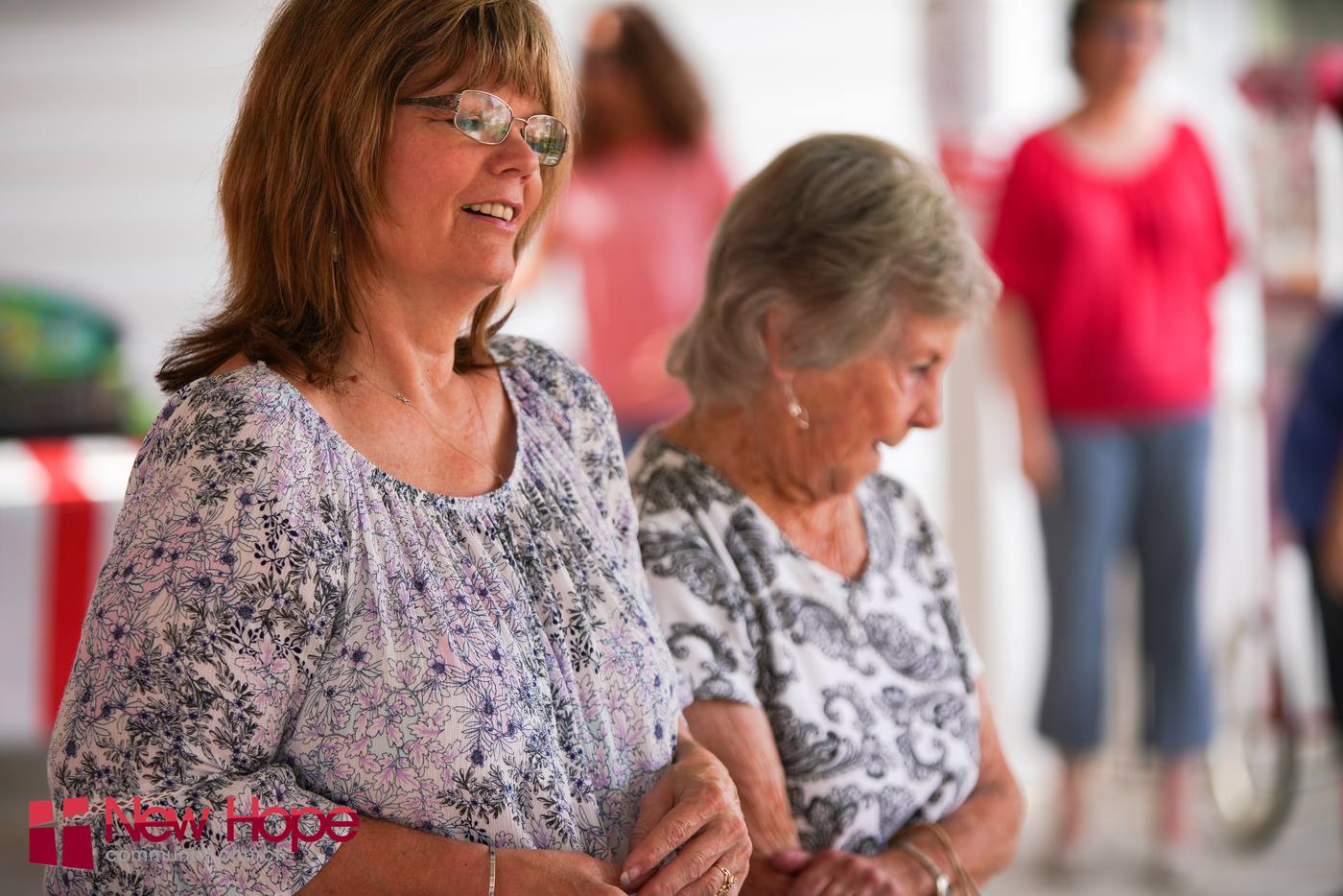 Two women smiling and laughing together at a New Hope community event in Clovis