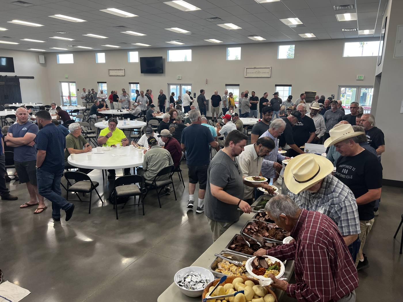 Men serving themselves from a barbecue line at a New Hope men's gathering