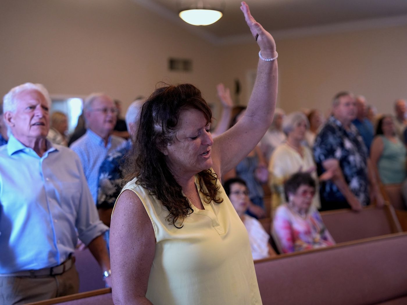 A New Hope member raising her hand in worship during a Sunday morning service