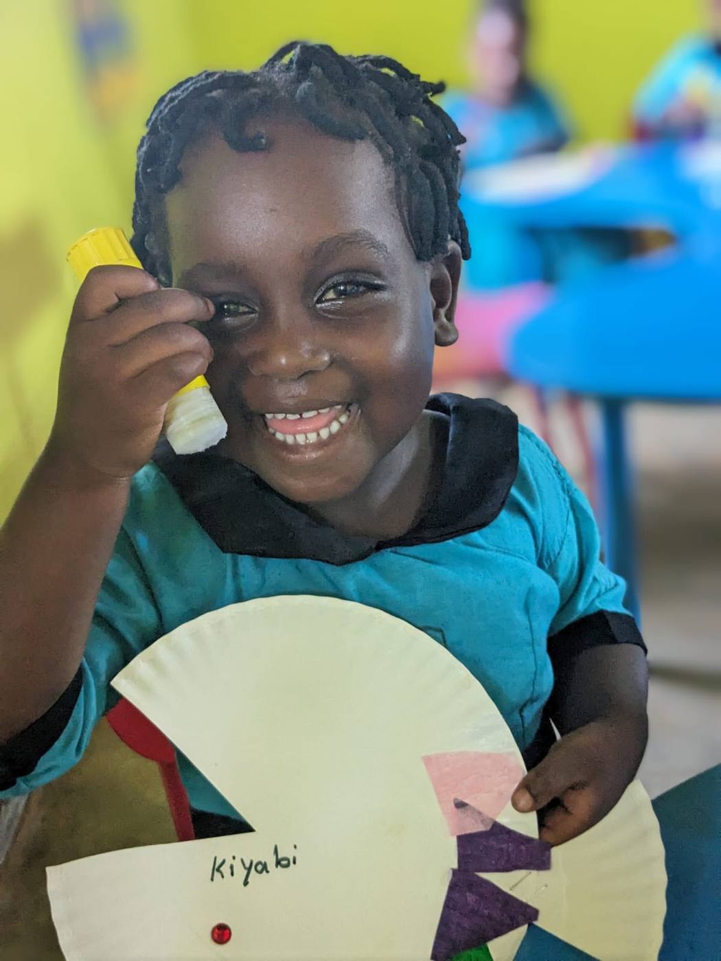 A young child smiling outdoors during a New Hope mission trip to Uganda