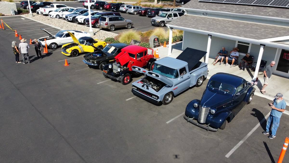 Classic cars and visitors filling the New Hope parking lot during a car show in Clovis