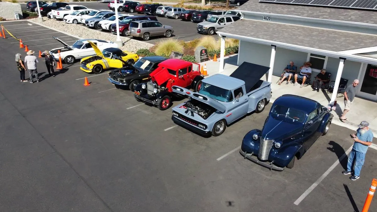Classic cars and visitors filling the New Hope parking lot during a car show in Clovis