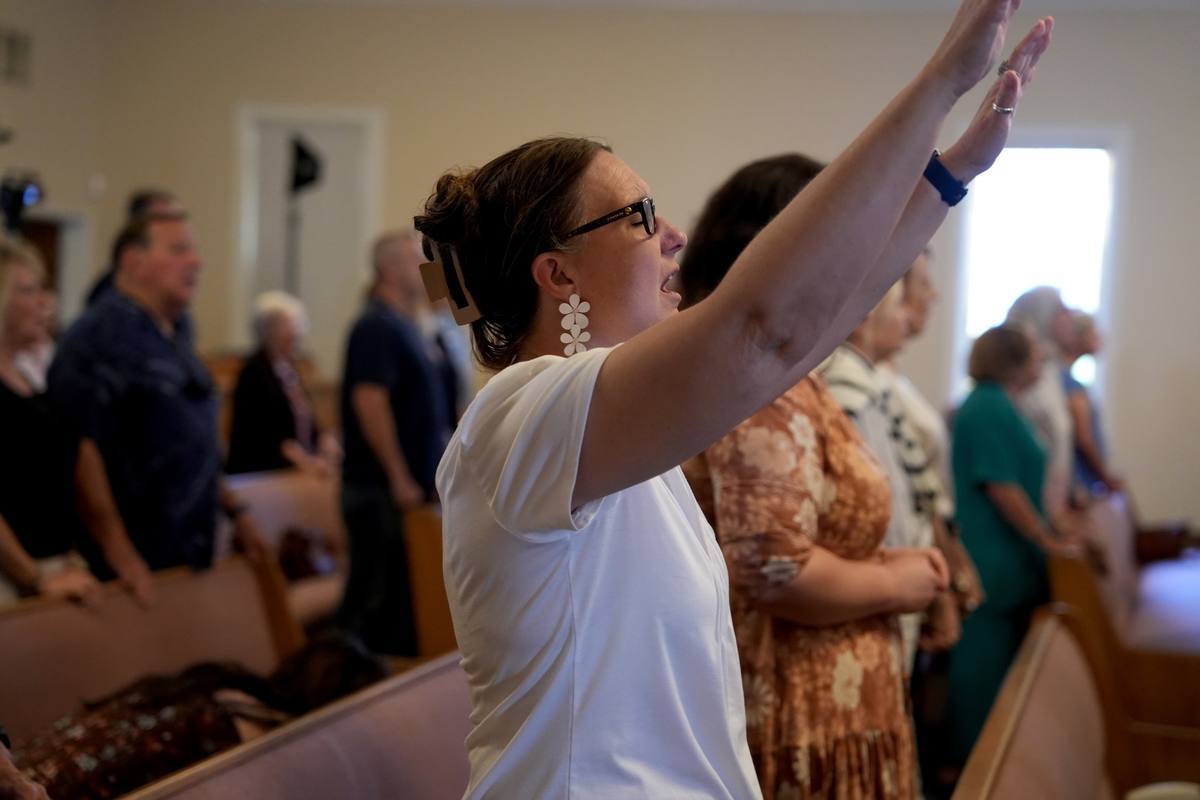Worship during a Sunday service at New Hope in Clovis, hands raised in the pews