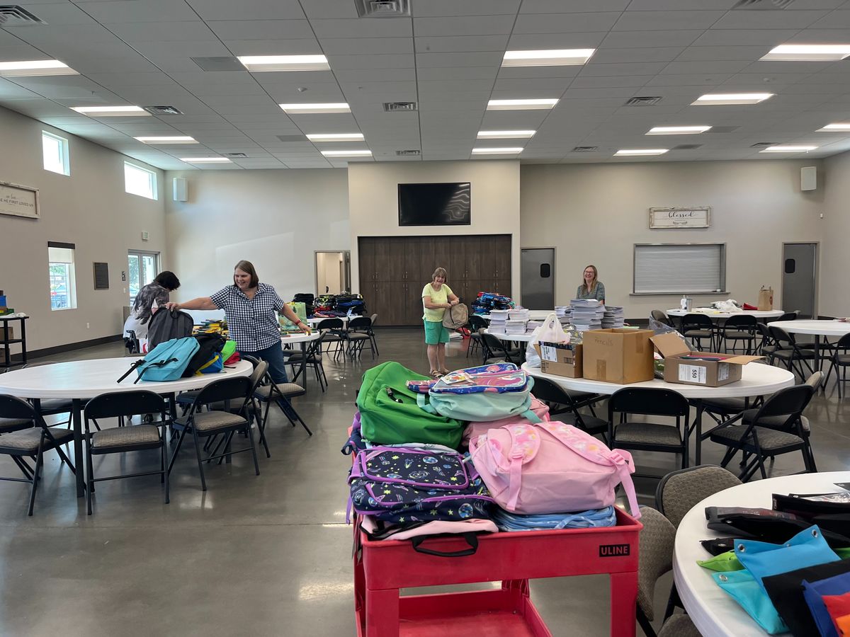 Volunteers sorting donated backpacks for New Hope's Back to School Drive in Clovis