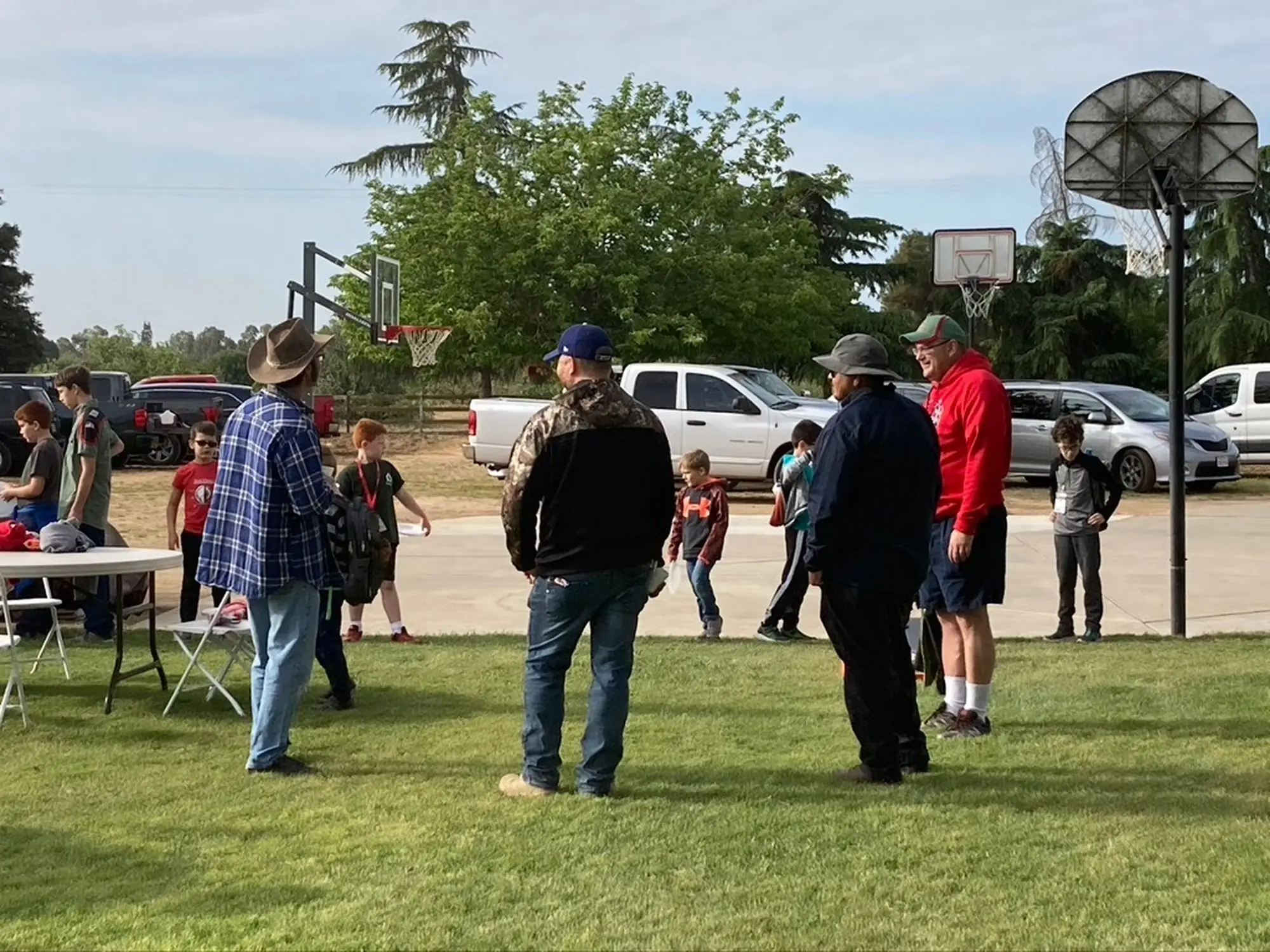 Trail Life dads and boys gathered on the field after an outdoor troop activity