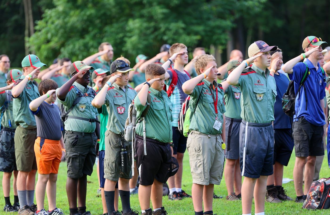 Trailmen and leaders standing at the salute outdoors in uniform