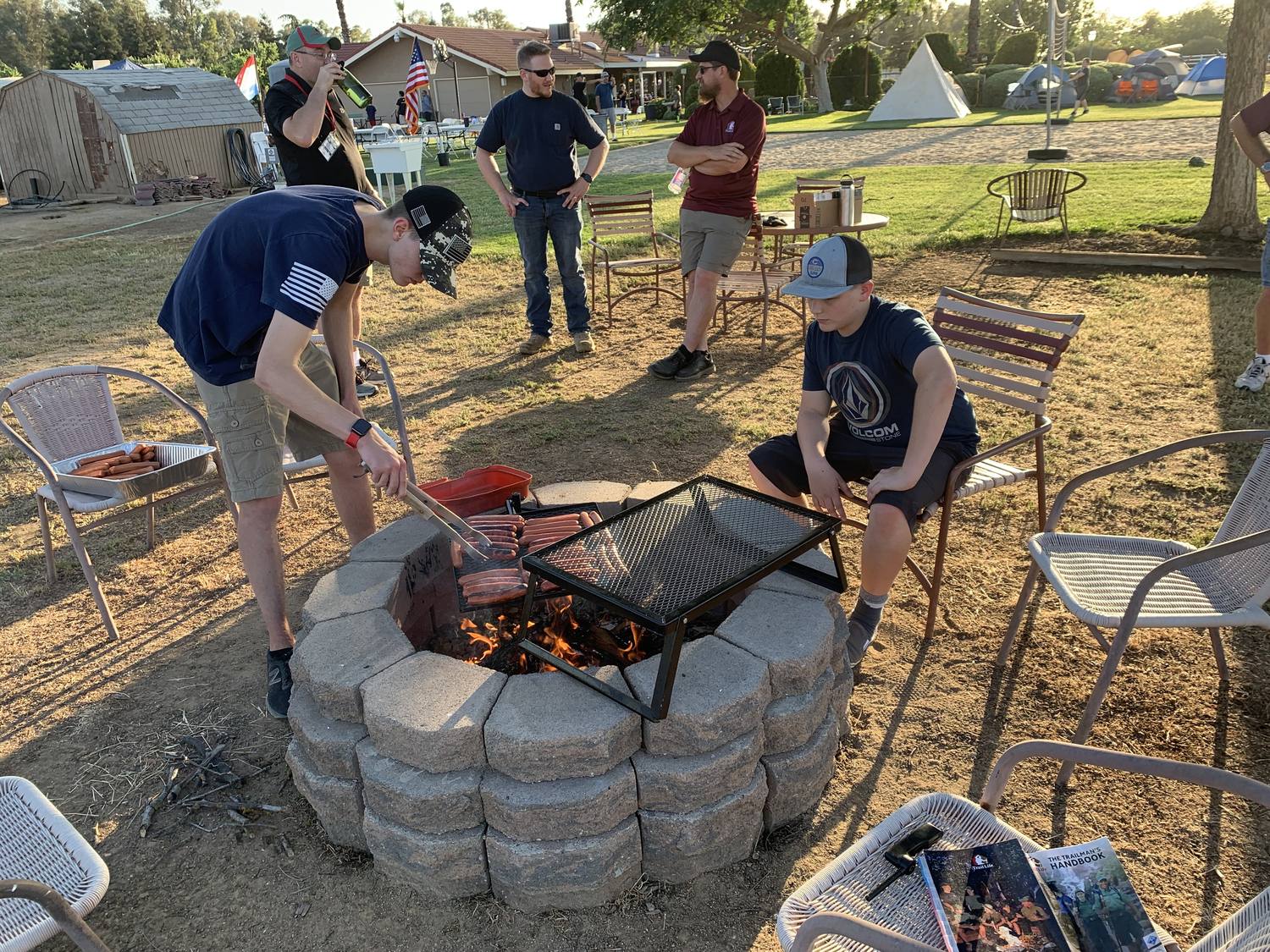 Trailmen cooking over an open fire at a troop campout