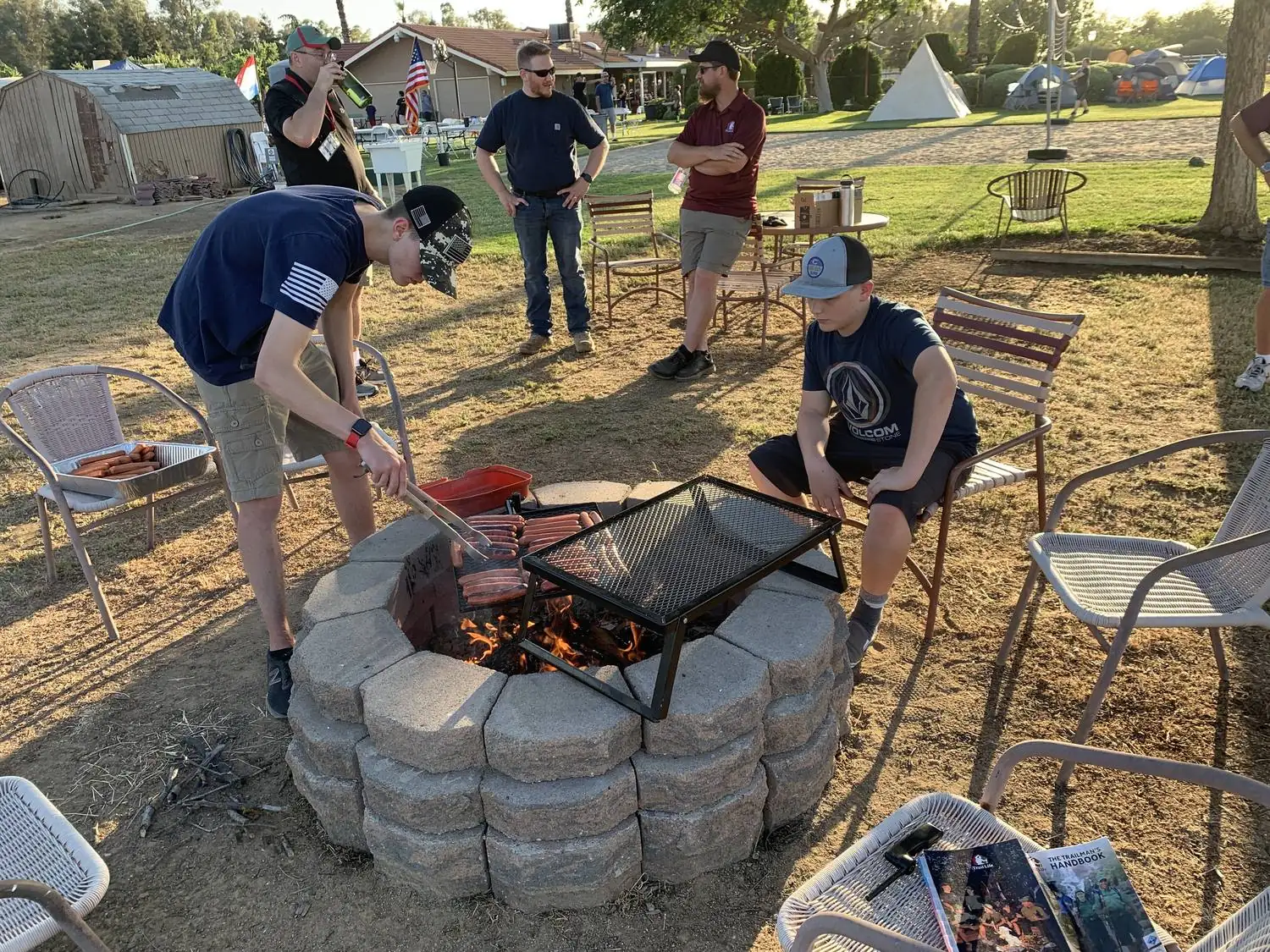 Trailmen cooking over an open fire at a troop campout
