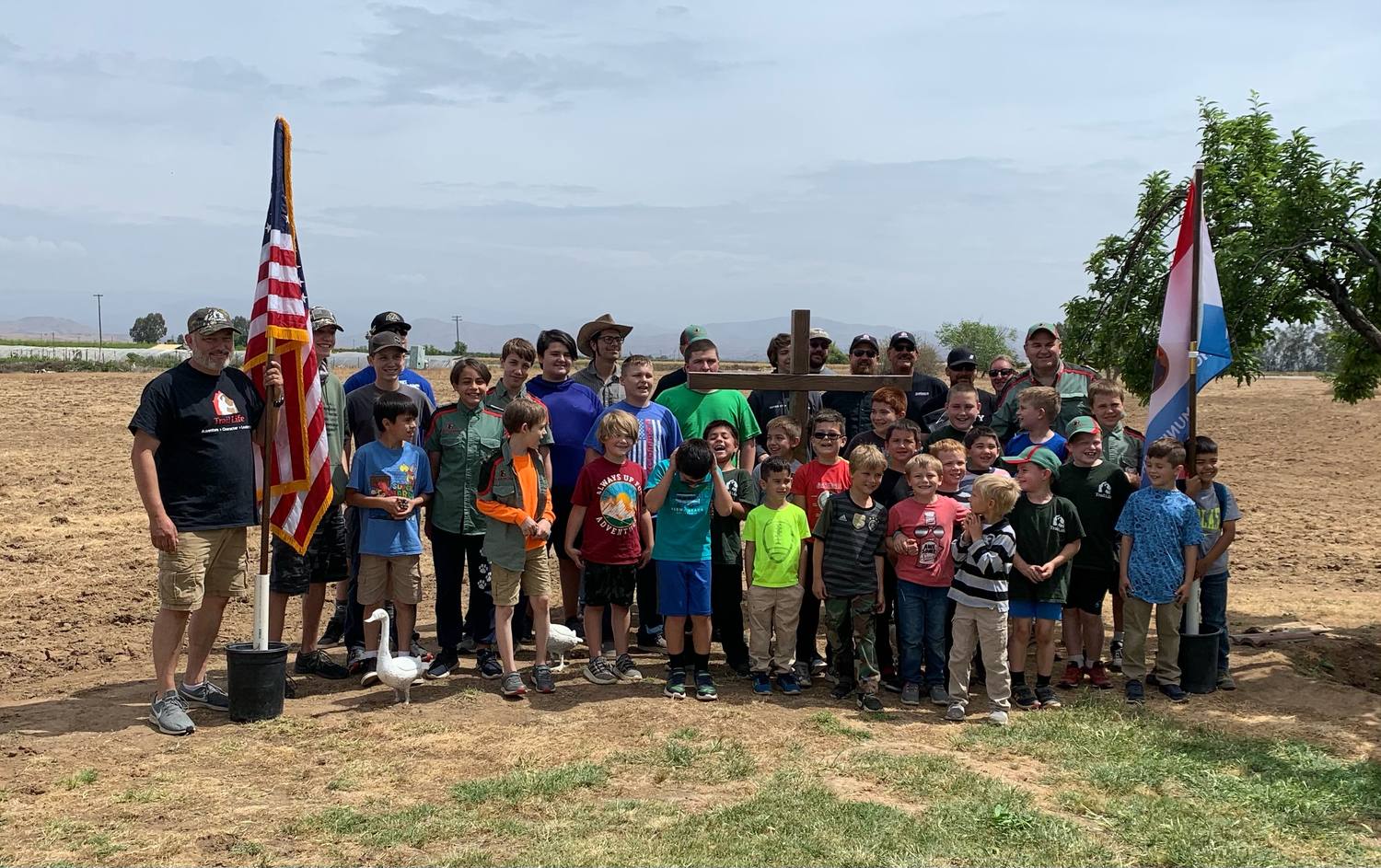 Trail Life Troop CA-4620 assembled outdoors behind the United States and troop flags