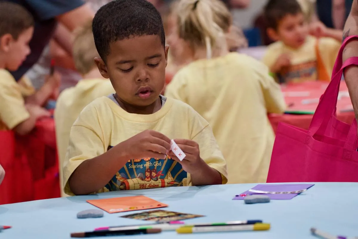 A young cadet folding a paper airplane craft at Skybound