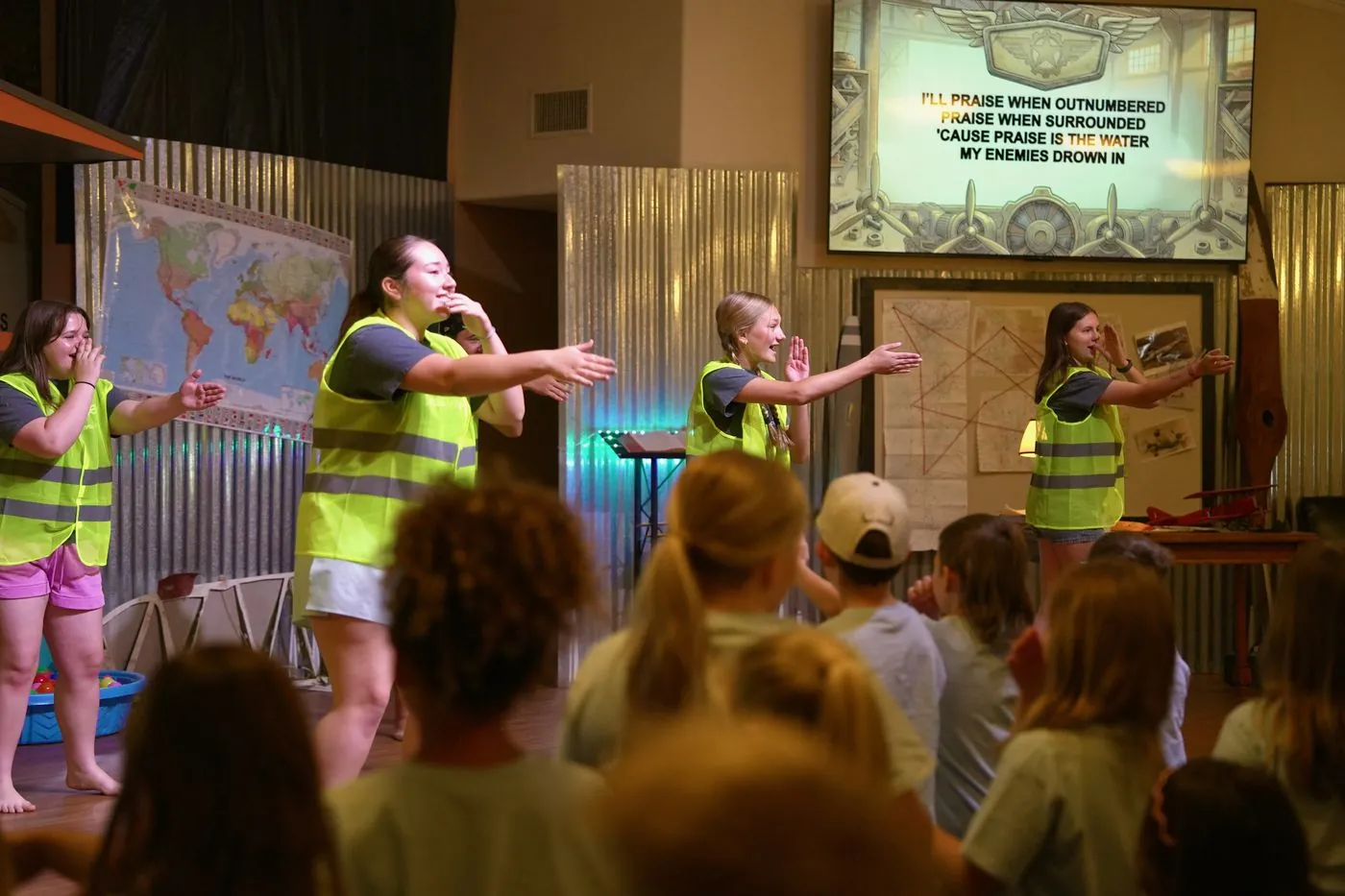 Flight Crew volunteers leading worship with hands raised