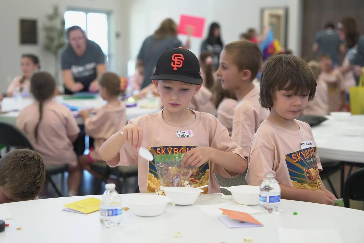 Cadets in Skybound t-shirts eating snacks at tables during VBS snack time