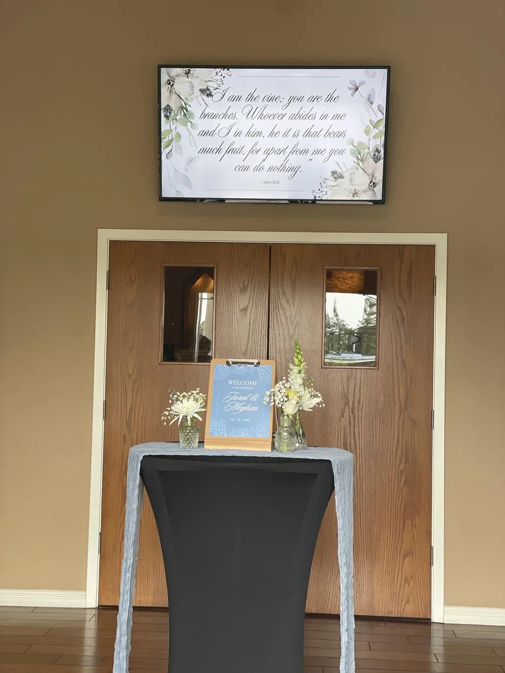 Welcome table with a sign and flowers at the sanctuary doors
